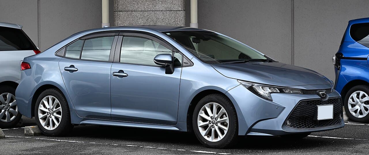Голубой седан Toyota Corolla E210 для японского рынка, вид спереди и сбоку