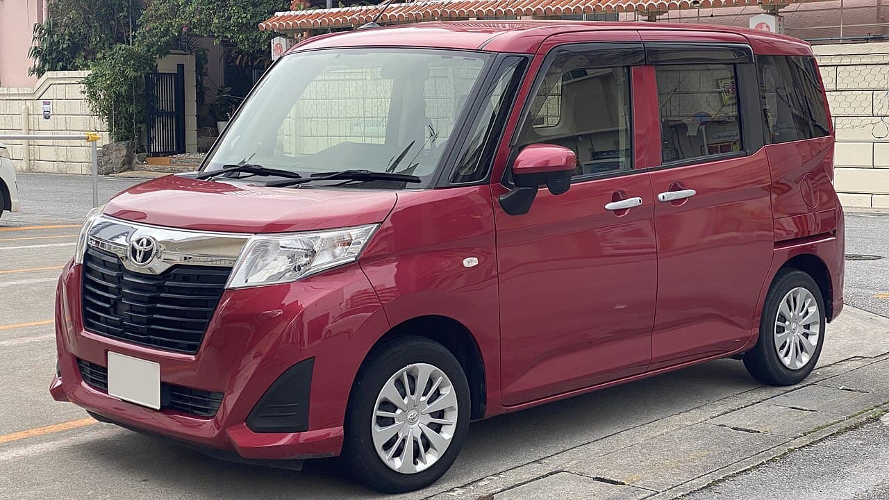 Красный Toyota Roomy X первого поколения, вид спереди и сбоку