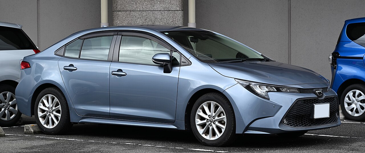 Голубой седан Toyota Corolla E210 для японского рынка, вид спереди и сбоку