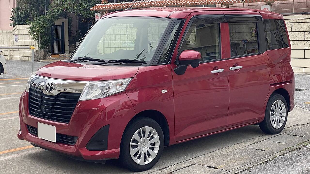 Красный Toyota Roomy X первого поколения, вид спереди и сбоку